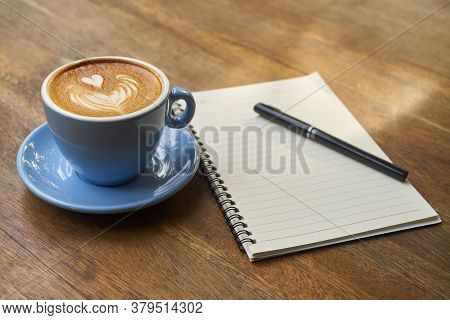 Hot Healthy And Tasty Coffie Drink On The Cup With Notebook