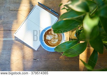 Hot Healthy And Tasty Coffie Drink On The Cup With Notebook