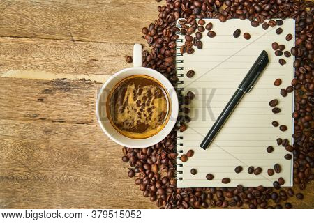 Hot Healthy And Tasty Coffie Drink On The Cup With Notebook