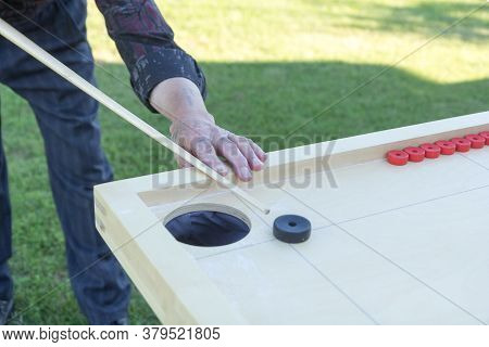 Man Playing Novuss In Outdoors. Novuss Is A National Sport In Latvia Similar To Pocket Billiards Or 