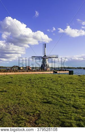 Windmill By The Canal At Glimmen In Holland. Around The Mills Are Excavators And The Background Is A