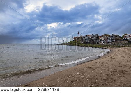 Sea And Beach At The Lighthouse In Urk In Holland. In The Background Are Storm Clouds With Dark Sky.