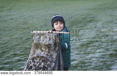 Portrait Of Happy Kid With Smiling Face Standing Behind Old Wall Holding Crossbow,  Active Child Boy
