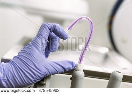 Hand In Blue Latex Glove And Saliva Ejector Symbolize Love In Dentistry. Heart Symbol. Dental Treatm