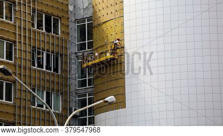 Worker Builder Making Construction For Ventilation Facade On A Building With Screwdriver Drill