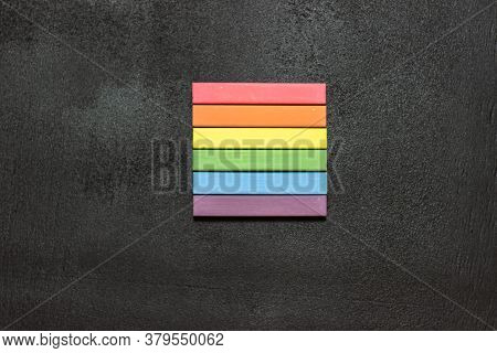 Lgbt Flag With Crayons On Chalkboard. A Rainbow Lined With Crayons. Black Background