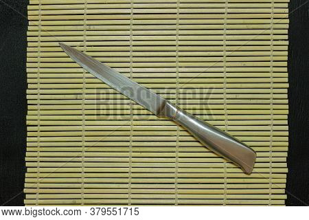 The Metal Knife Lies On The Sushi Mat.