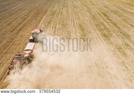 Aerial View. Tractor With Seed Drill Machine Sowing The Seeds For Crops In Spring Season. Beginning 