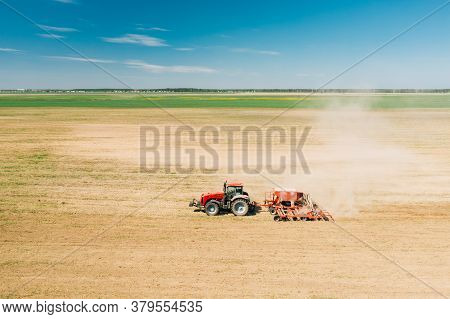 Aerial View. Tractor With Seed Drill Machine Sowing The Seeds For Crops In Spring Season. Beginning 