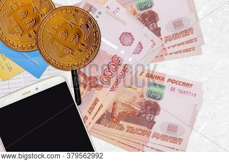 5000 Russian Rubles Bills And Golden Bitcoins With Smartphone And Credit Cards. Cryptocurrency Inves