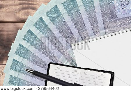 5 Egyptian Pounds Bills Fan And Notepad With Contact Book And Black Pen. Concept Of Financial Planni