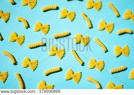 Uncooked Curly Pasta Pattern On Blue Background. Traditional Dry Raw Macaroni Pattern. Nobody