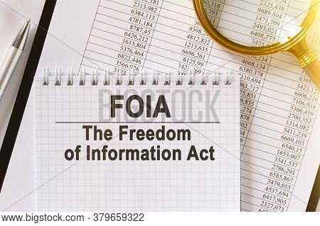 On The Table Are Financial Reports, A Pen, A Magnifying Glass And A Notebook With The Inscription - 