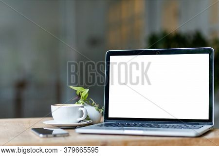 Mockup Of Laptop Computer With Empty Screen With Coffee Cup And Smartphone On Table Of The Coffee Sh