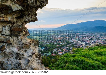 Ruins Of Old Hungarian Castle With A City View At Sunset, Khust, Western Ukraine.