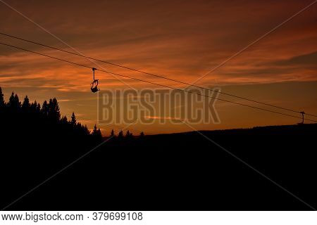 Ski Chair Lift In The Mountains At Red Sunset