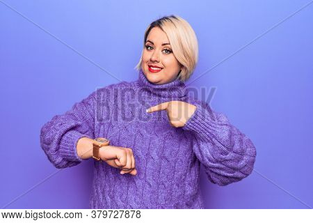 Beautiful blonde plus size woman wearing casual turtleneck sweater over purple background In hurry pointing to watch time, impatience, upset and angry for deadline delay