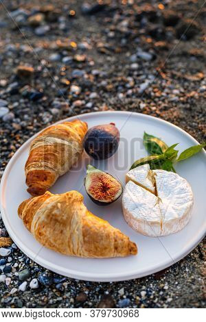 Vertical Image Of The Beach Picnic With Figs, Croissants And Camamber Cheese. Negative Space.