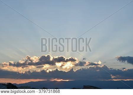 Sunset With Lights Crossing The Clouds In The Sky