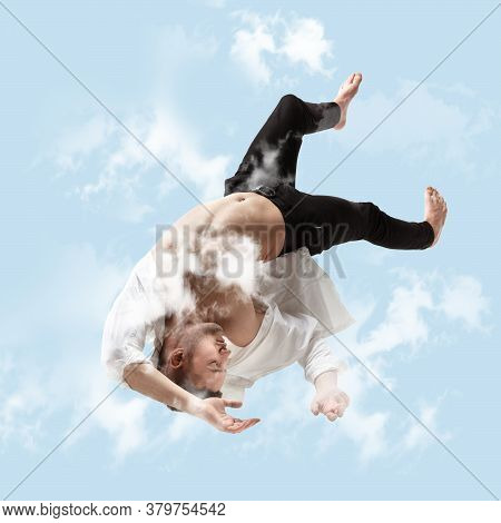 Mid-air Beauty Cought In Sky. Full Length Shot Of Young Man Hovering In Air And Keeping Eyes Closed.