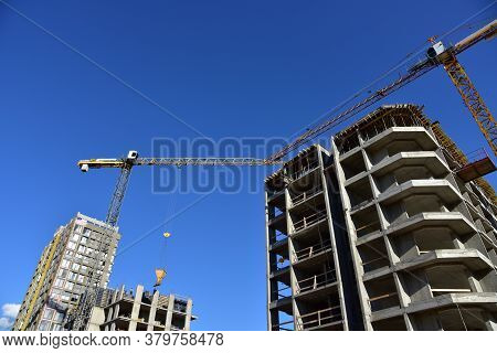 Preparing To Pour A Bucket Of Concrete Into Formwork.tower Crane Lifting Cement Bucket During Constr