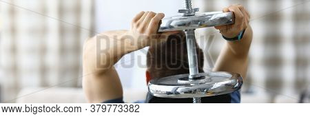 Male Athlete Doing Sports At Home With Dumbbell. Strength Training And Muscle Building At Home. Orga