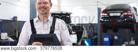 Car Repairman Standing Workshop With Folder Hands. Checking Original Mileage Car. Inspection Cabin A