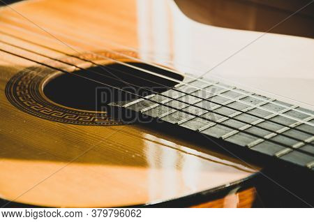 Close-up Of Guitar Strings In Sunlight. Guitar Fretboard Part, Acoustic Six-string Wooden Guitar, St