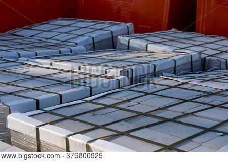 Paving Slabs On Wooden Pallets Wrapped In Transparent Plastic Wrap At A Construction Site