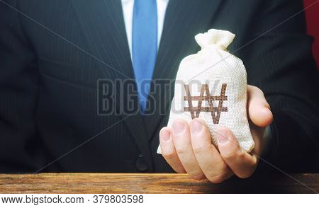 A Businessman Holds In His Hand A South Korean Won Money Bag. Stimulating Economic Recovery. Investm