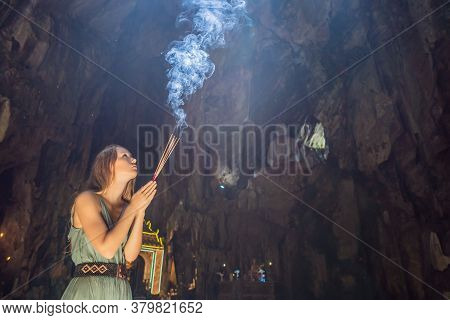 Young Woman Praying In A Buddhist Temple Holding Incense Huyen Khong Cave With Shrines, Marble Mount