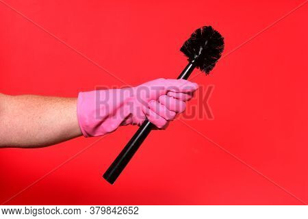 Hand With Glove Holding Brush On Red Background