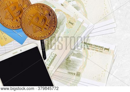 1 Chinese Yuan Bills And Golden Bitcoins With Smartphone And Credit Cards. Cryptocurrency Investment