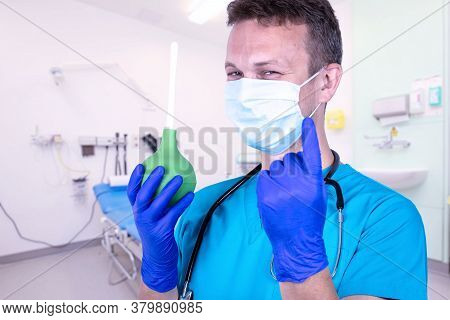 Medical Concept Of The Prostate. The Doctor Holds An Enema With A Hint Of Bowel Lavage.