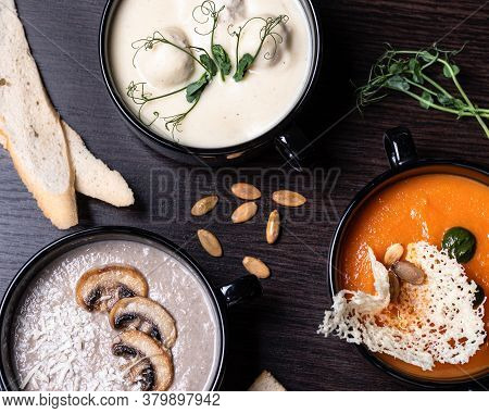 Mushroom Cream Soup In A Black Plate With Croutons Of White Bread. Cream Of Champignon Soup With Cra