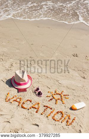 Inscription Vacation Made Of Amber Stones, Accessoriess For Sunbathing And Passport On Sand At Beach
