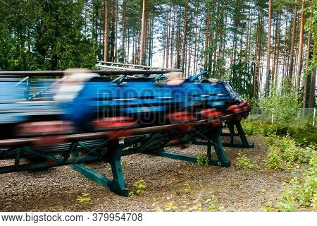 Ride Roller Coaster In Motion In Amusement Park At Summer Day