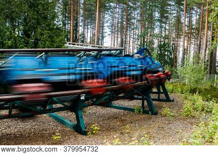 Ride Roller Coaster In Motion In Amusement Park At Summer Day