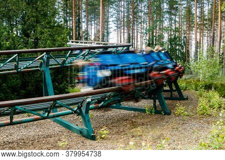 Ride Roller Coaster In Motion In Amusement Park At Summer Day