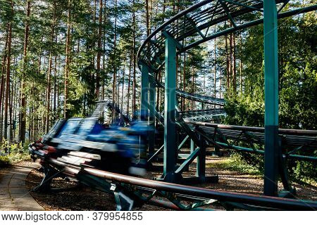 Ride Roller Coaster In Motion In Amusement Park At Summer Day
