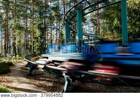 Ride Roller Coaster In Motion In Amusement Park At Summer Day