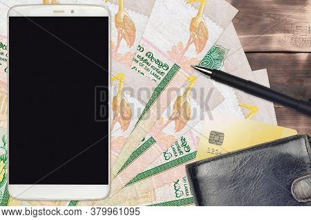 10 Sri Lankan Rupees Bills And Smartphone With Purse And Credit Card. E-payments Or E-commerce Conce