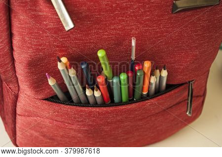 Colored Pencils, A Paintbrush Look Out Of A School Bag Pocket. Preparing For School.