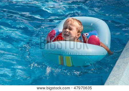 เด็กชาย Swims ในสระว่ายน้ำ