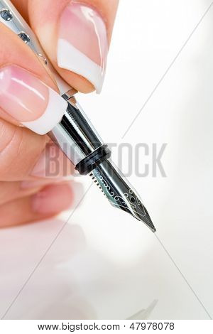 una donna firma un contratto o un testamento con una penna stilografica.