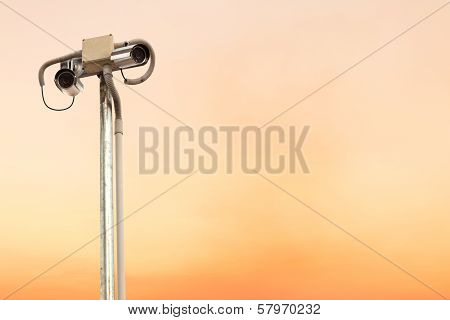 Security camera or cctv on colorful sky.