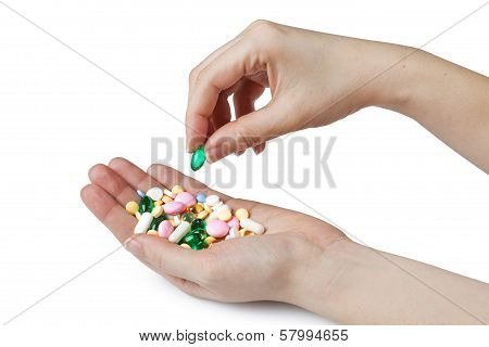 womens hands holding colored pills