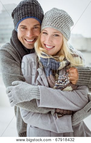 Cute couple in warm clothing smiling at camera on a chilly day