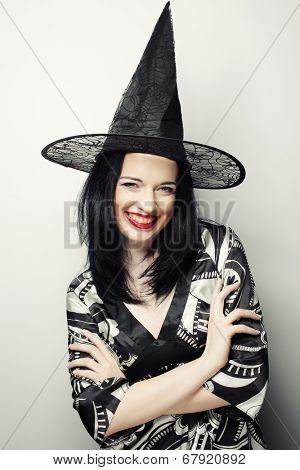 Funny Witch. Young happy woman with canival hat. Studio shot.