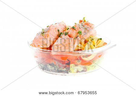 fresh fried natural pink salmon on italian traditional tagliatelle backed with tomato and vegetables isolated over white background